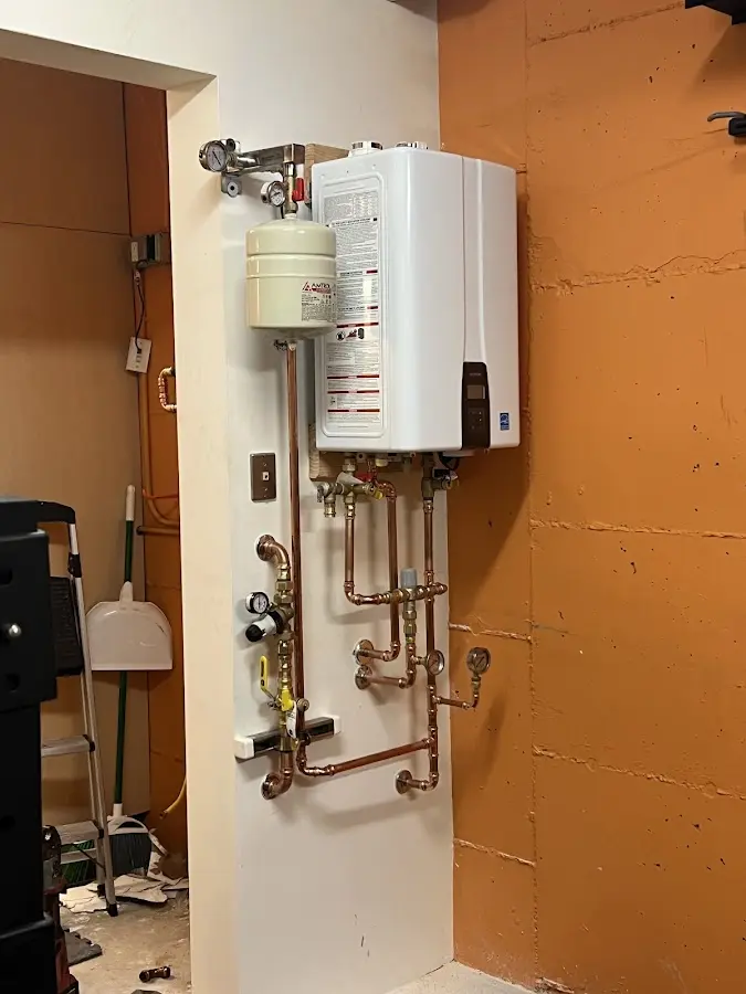 Plumbing technician inspecting water heater connections in Helena